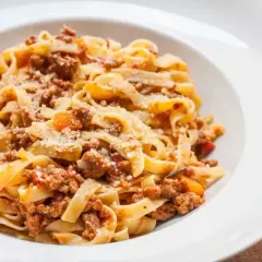Tagliatelle z bogatym sosem mięsnym, posypane parmezanem. Idealny przepis na ragu, który zachwyci każdego.