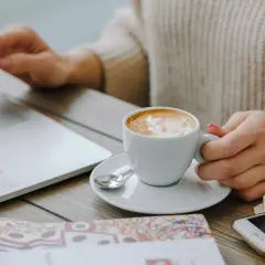 Kawa Davidoff rozpuszczalna, która najlepsza? Pyszne latte z pianką obok laptopa i telefonu.