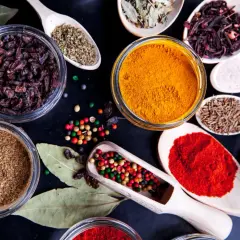 Kolorowe przyprawy, w tym kurkuma, papryka i kmin rzymski, ułożone na czarnym tle. Idealne do przygotowania aromatycznego garam masala przepis.