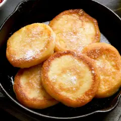 Szybkie placuszki serowe w 5 minut, lekko oprószone cukrem pudrem, gotowe do podania z konfiturą.