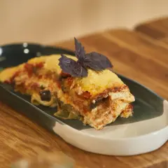 Pyszna lasagne z bakłażanem i pomidorami, udekorowana bazylią. Idealna, gdy zastanawiasz się, jak podgrzać lasagne w mikrofali.