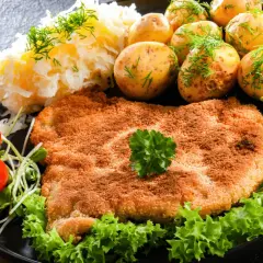 Złocisty kotlet słoneczny, podany z ziemniaczkami, mizerią i pomidorkami. Pyszny obiad!