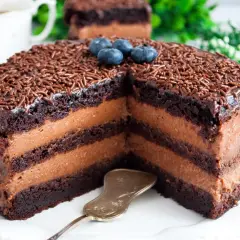 Obłędny tort czekoladowy z mascarpone i owocami, posypany czekoladową posypką i udekorowany borówkami. Idealny na każdą okazję!