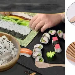 Przygotowanie sushi: ryż z sezamem, nori, ogórek, łosoś, gotowe rolki i bambusowe pałeczki.