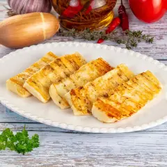 Pyszne halloumi z grilla, idealne na letnie przekąski. Złociste paski na serze świadczą o jego doskonałym przygotowaniu.