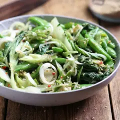 Zielona sałatka z pak choi, groszku cukrowego i cebuli, posypana sezamem. Idealna do dań kuchni azjatyckiej, świetne kapusta pak choi przepisy.