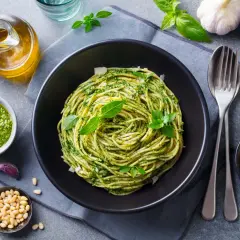 Pyszny pomysł na obiad bez mięsa: spaghetti z pesto, świeżą bazylią, orzeszkami pinii i parmezanem.
