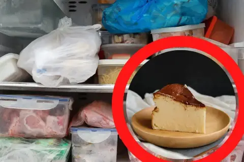Kawałek pysznego sernika na talerzyku, otoczony przez zamrożone jedzenie w zamrażarce. Czy sernik można zamrozić? Tak, aby cieszyć się nim później!