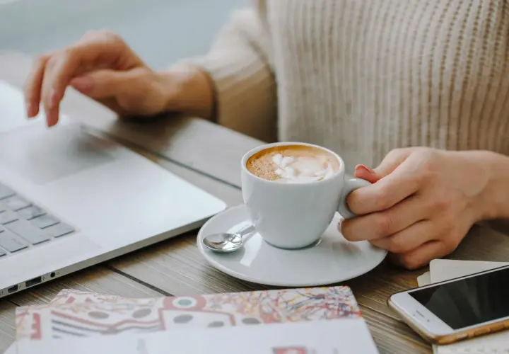 Kawa Davidoff rozpuszczalna, która najlepsza? Pyszne latte z pianką obok laptopa i telefonu.