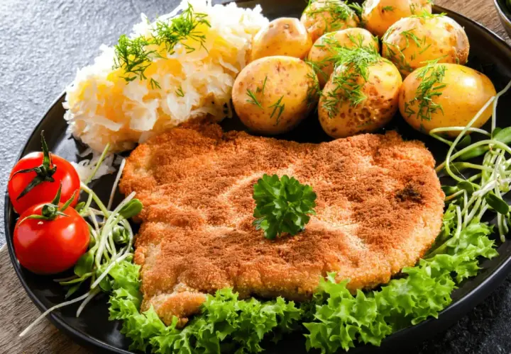 Złocisty kotlet słoneczny, podany z ziemniaczkami, mizerią i pomidorkami. Pyszny obiad!