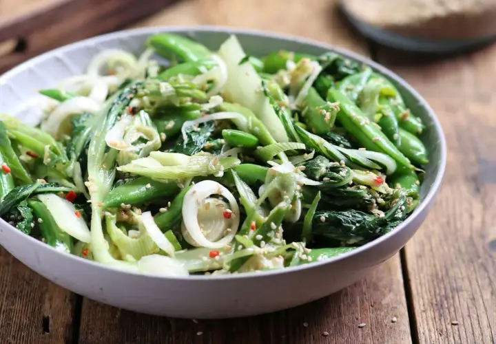 Zielona sałatka z pak choi, groszku cukrowego i cebuli, posypana sezamem. Idealna do dań kuchni azjatyckiej, świetne kapusta pak choi przepisy.