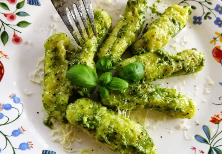 Pyszne domowe gnocchi z pesto, posypane parmezanem i udekorowane listkami bazylii. Idealne danie dla miłośników włoskich smaków.
