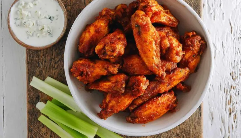 Chrupiące skrzydełka z airfryer w misce, obok sosu blue cheese i łodyg selera. Idealna przekąska!
