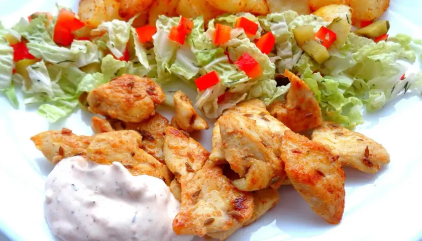 Pyszna shoarma z kurczaka z chrupiącymi ziemniaczkami, świeżą sałatką i kremowym sosem.