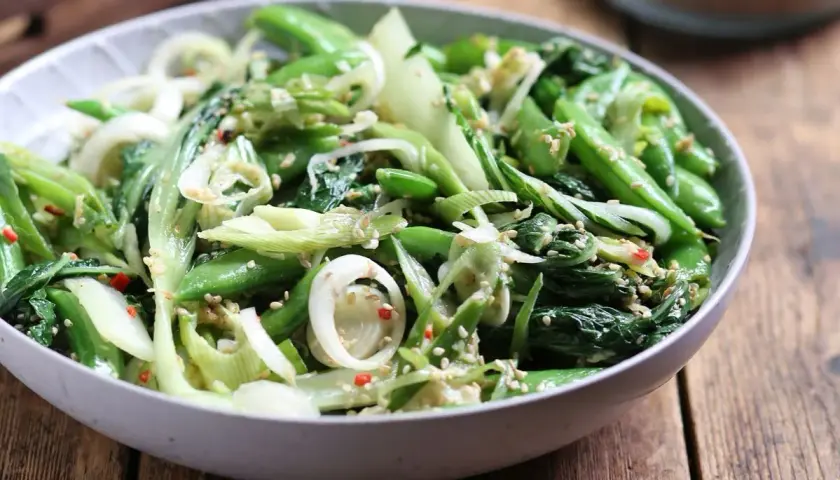 Zielona sałatka z pak choi, groszku cukrowego i cebuli, posypana sezamem. Idealna do dań kuchni azjatyckiej, świetne kapusta pak choi przepisy.