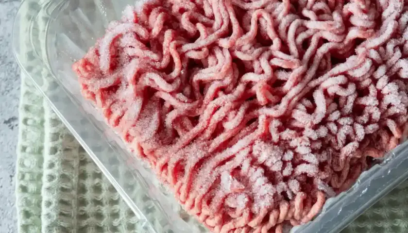 Mrożone mięso mielone w plastikowym opakowaniu, gotowe do rozmrożenia w mikrofali.