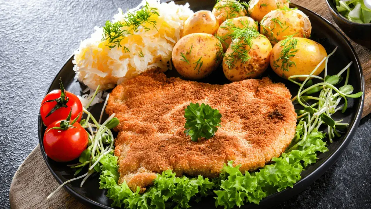 Złocisty kotlet słoneczny, podany z ziemniaczkami, mizerią i pomidorkami. Pyszny obiad!