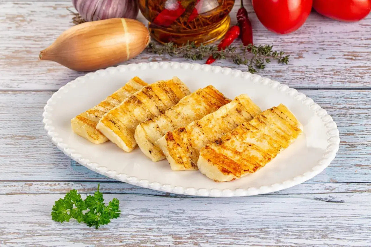 Pyszne halloumi z grilla, idealne na letnie przekąski. Złociste paski na serze świadczą o jego doskonałym przygotowaniu.
