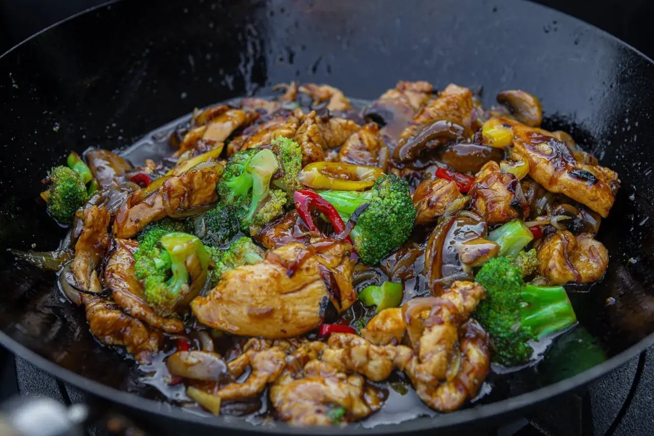 Pyszny kurczak z brokułami i grzybami w sosie, przygotowany metodą stir fry.