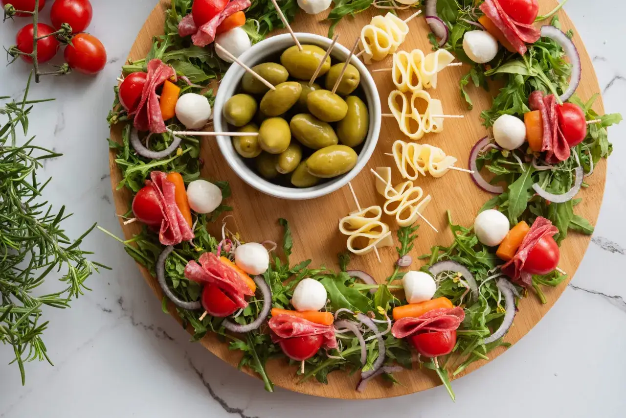 Proste przepisy na przekąski w 15 minut: kolorowe szaszłyki z pomidorkami, mozzarellą, salami i rukolą, oliwki i serowe zawijasy.