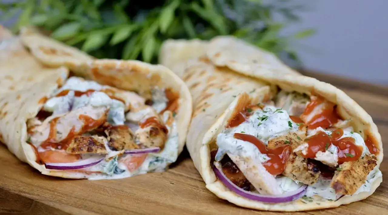 Dwa pyszne gyrosy w tortilli, pełne soczystego kurczaka, warzyw i sosu. Idealne na szybki obiad, zgodnie z klasycznym gyros przepisem.