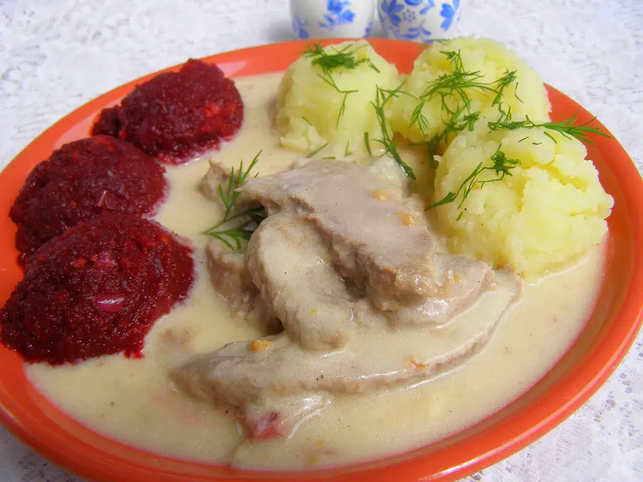 Ozorki w sosie chrzanowym Ani gotuje. Danie z ziemniakami i buraczkami na pomarańczowym talerzu.