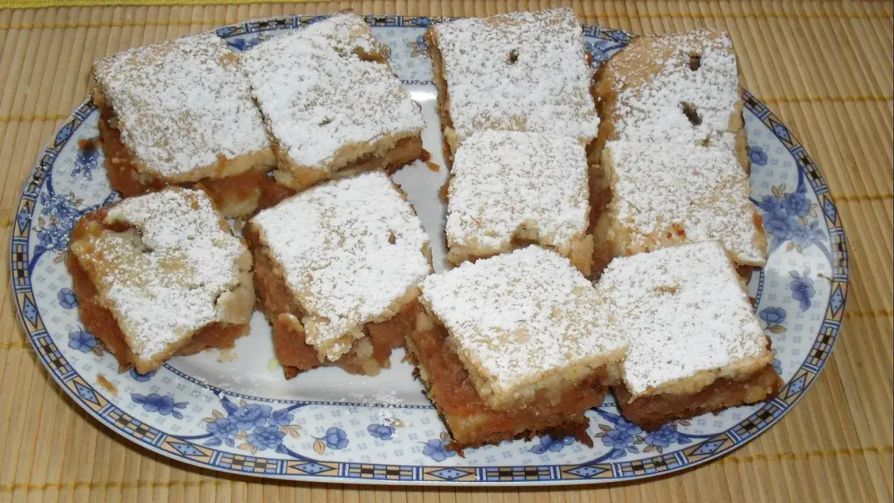 Pyszne ciasto jabłkowe, posypane cukrem pudrem, wygląda jak jedno z 10 najlepszych ciast. Idealne na deser.