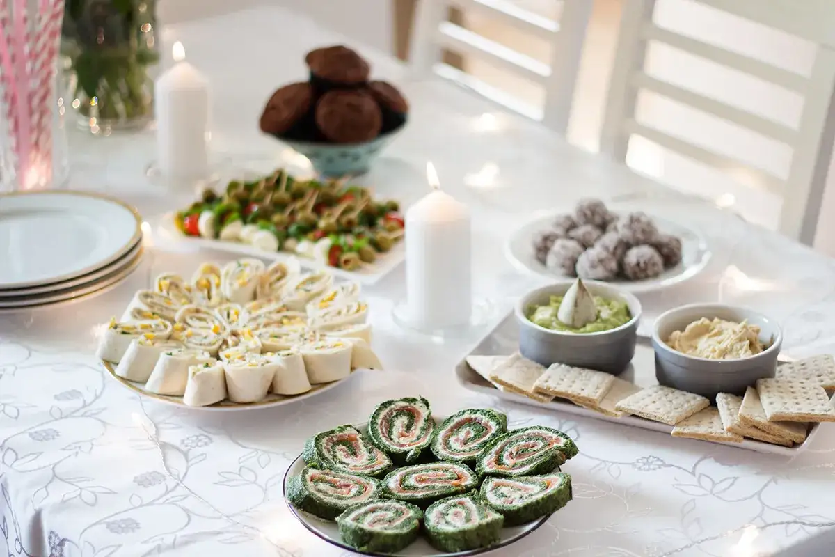 Pyszne menu na sylwestra w domu: roladki z tortilli, zielone roladki z łososiem, przekąski caprese, ciasteczka i dipy.