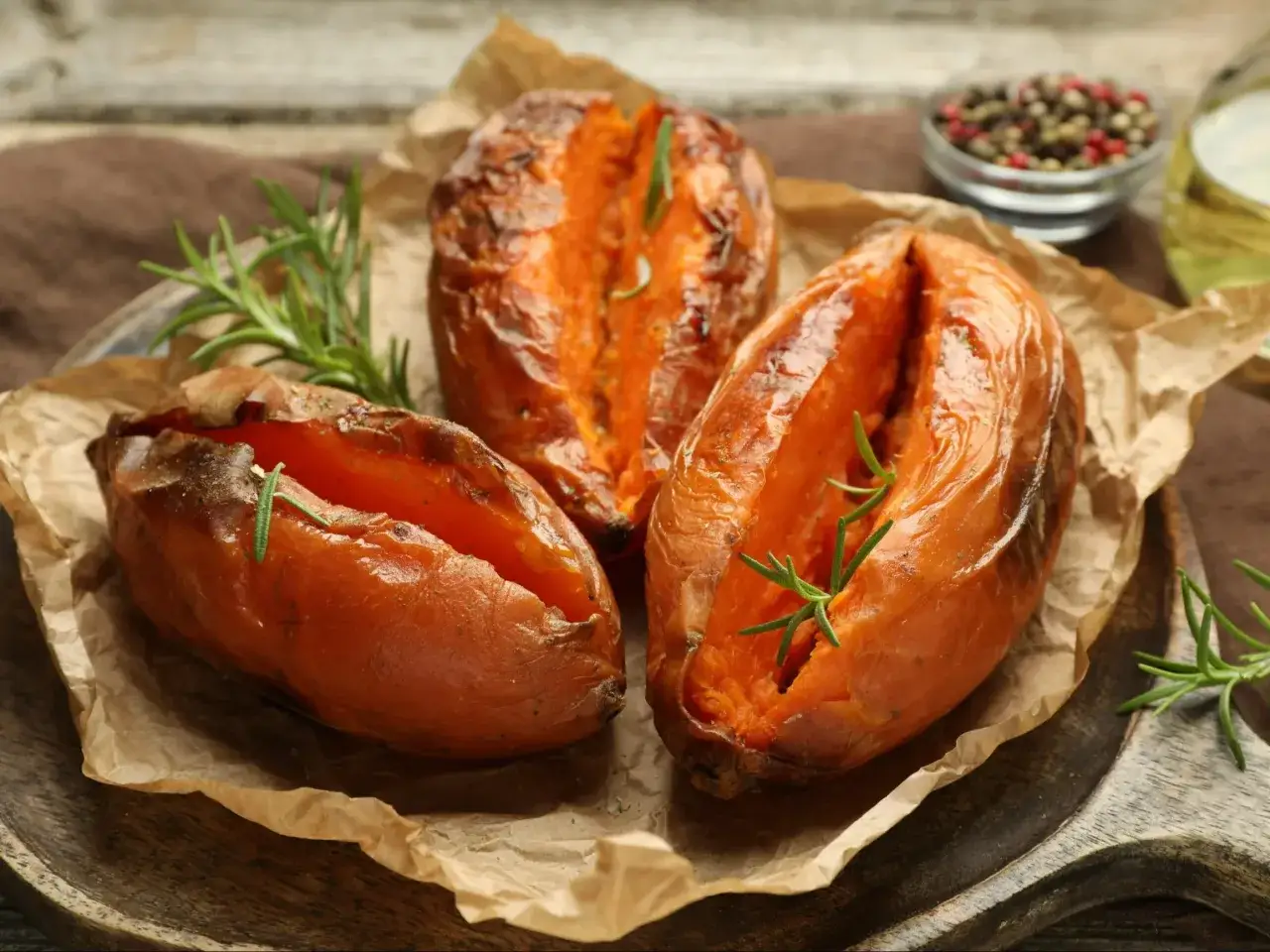 Aromatyczne bataty z piekarnika, pieczone z rozmarynem, prezentują się apetycznie na brązowym papierze.