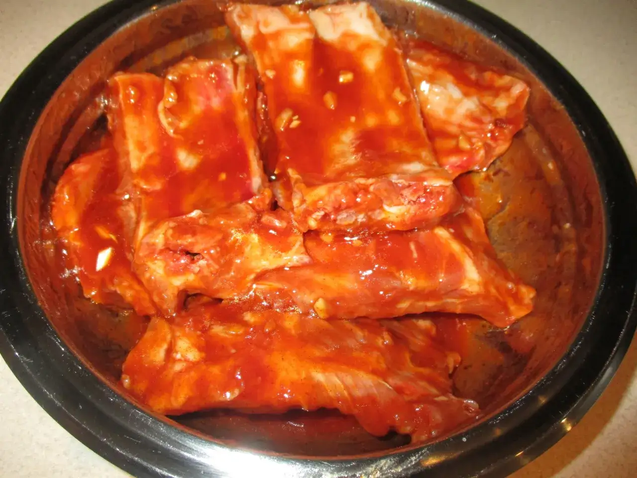 Żeberka w misce, gotowe do pieczenia. Ten przepis na żeberka w miodzie i keczupie zapowiada pyszne danie.